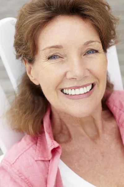 Portrait of a smiling mature woman representing verified user satisfaction, healthy hearing recovery, and lifestyle quality.