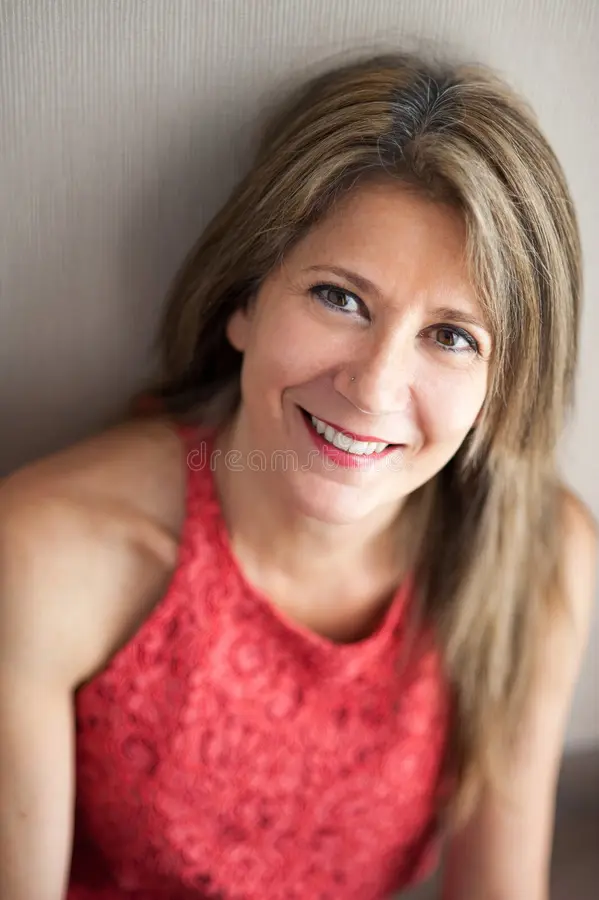 Portrait of a smiling adult woman with blonde hair, reflecting energy, vitality, and active body balance.