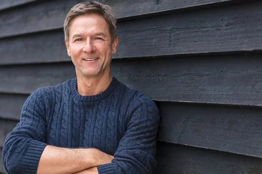 Portrait of a smiling mature man representing verified user satisfaction, healthy hearing recovery, and lifestyle quality.
