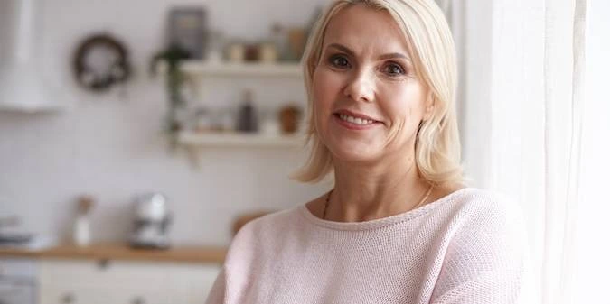 Portrait of a smiling adult woman with blonde hair, reflecting energy, vitality, and active body balance.