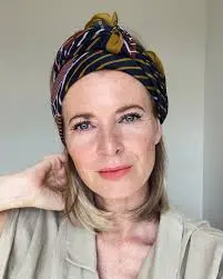 Close-up of a smiling woman with a colorful head wrap, illustrating daily confidence and fresh breath satisfaction.